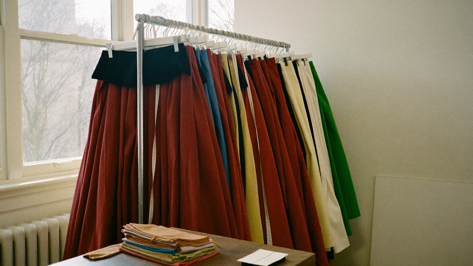 Rack of folkloric skirts and a measuring tape in a dance program workroom