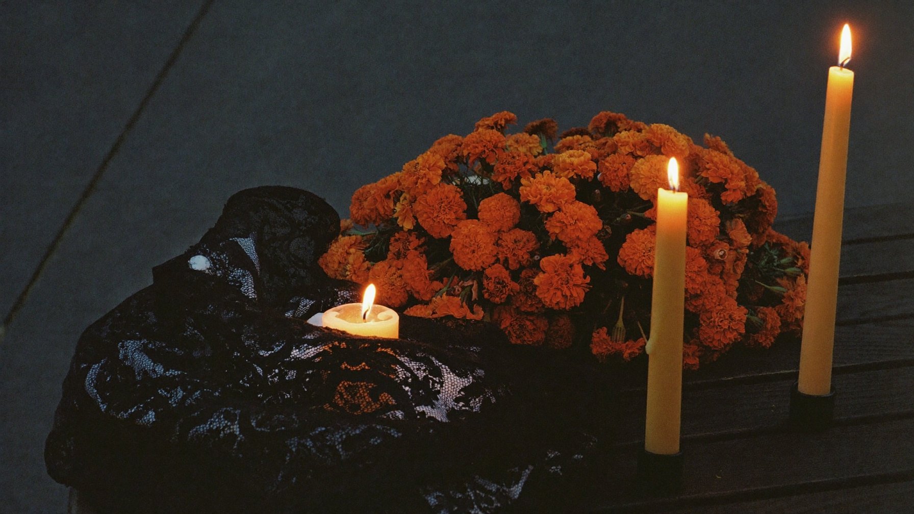 Marigolds, black lace rebozo and candles on a Dia de los Muertos altar